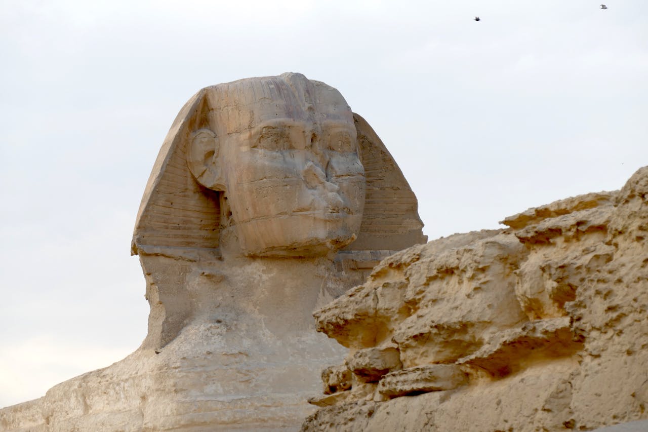 Voyageur consultant son smartphone devant le Sphinx de Gizeh